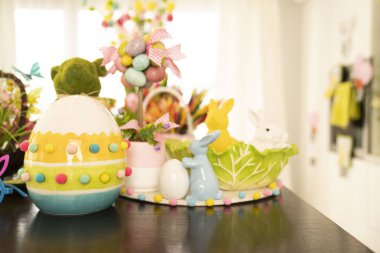 Paskalya zamanı. Parlayan ahşap masada Paskalya süsleri. Paskalya tavşanı, sepette paskalya yumurtası ve lahana yaprağı..