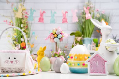 Paskalya zamanı. Beyaz arka planda Paskalya süslemeleri. Paskalya tavşanı, sepetteki paskalya yumurtaları. Bahar çiçekleri.. 