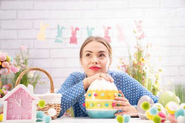 Paskalya süsleri hazırlayan güzel genç kadınlar. Paskalya geçmişi. Bahar çiçekleri. Sepetlerdeki Paskalya yumurtaları.