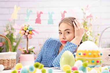 Paskalya süsleri hazırlayan güzel genç kadınlar. Paskalya geçmişi. Bahar çiçekleri. Sepetlerdeki Paskalya yumurtaları.