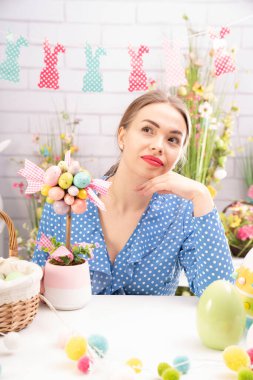 Paskalya süsleri hazırlayan güzel genç kadınlar. Paskalya geçmişi. Bahar çiçekleri. Sepetlerdeki Paskalya yumurtaları.