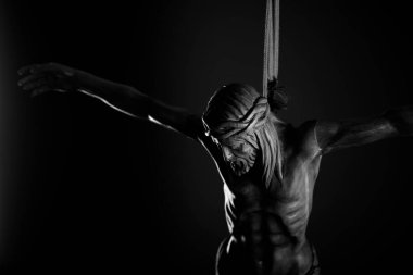 Din teması, Yüce İsa. Çarmıha gerilmiş İsa figürü karanlık arka planda izole edilmiş..