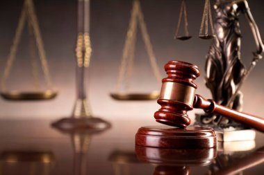 Hukuk ve adalet kavramı. Savaş suçları. Gavel, avukatlık bürosunda heykel ve terazi var. Kahverengi arkaplan.
