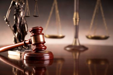 Hukuk ve adalet kavramı. Savaş suçları. Gavel, avukatlık bürosunda heykel ve terazi var. Kahverengi arkaplan.