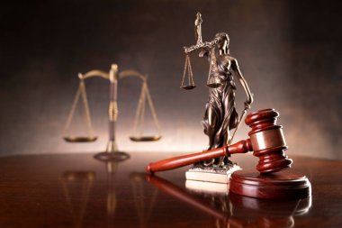Hukuk ve adalet kavramı. Savaş suçları. Gavel, avukatlık bürosunda heykel ve terazi var. Kahverengi arkaplan.