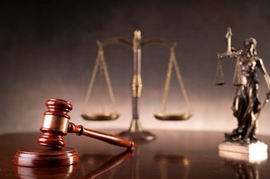 Hukuk ve adalet kavramı. Savaş suçları. Gavel, avukatlık bürosunda heykel ve terazi var. Kahverengi arkaplan.