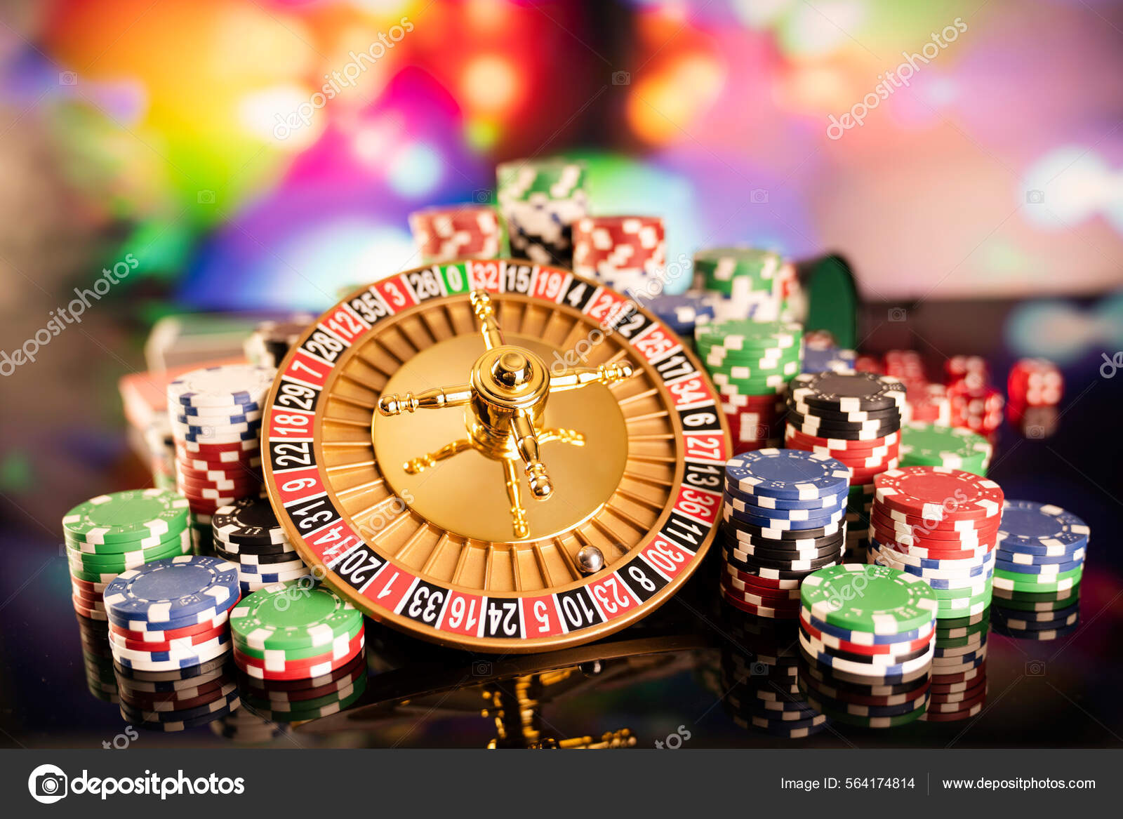赌场的主题赌博游戏色彩斑斓的背景上的轮盘赌和扑克筹码——图库图片© zolnierek #564174814