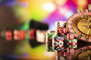 Kumarhane teması. Kumar oyunları. Renkli bir arka planda rulet ve poker fişleri.