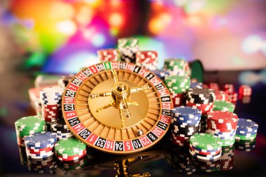 Kumarhane teması. Kumar oyunları. Renkli bir arka planda rulet ve poker fişleri.