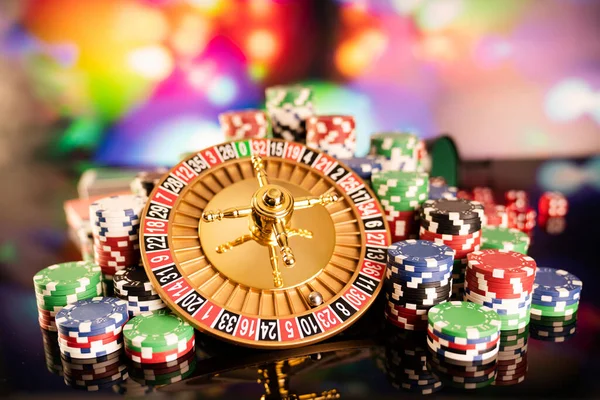 Kumarhane teması. Kumar oyunları. Renkli bir arka planda rulet ve poker fişleri.
