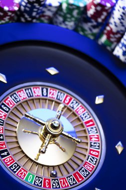 Kumarhane teması. Kumar oyunları. Mavi arka planda rulet ve poker fişleri.
