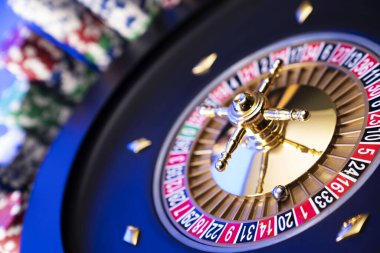 Kumarhane teması. Kumar oyunları. Mavi arka planda rulet ve poker fişleri.
