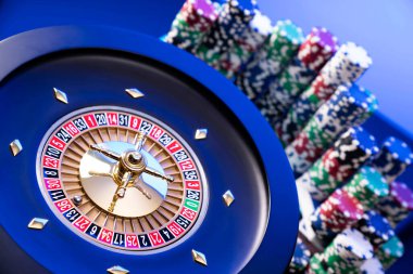 Kumarhane teması. Kumar oyunları. Mavi arka planda rulet ve poker fişleri.