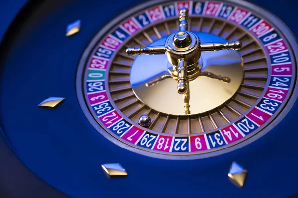 Kumarhane teması. Kumar oyunları. Mavi arka planda rulet ve poker fişleri.