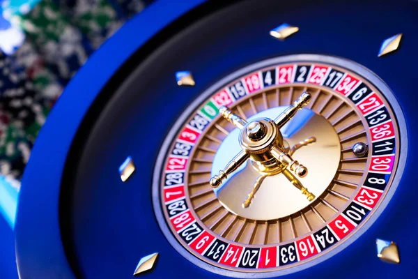 Kumarhane teması. Kumar oyunları. Mavi arka planda rulet ve poker fişleri.
