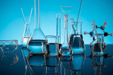 Covid 'e karşı test ve ilaç ile ilgili laboratuvar araştırmaları. Mikroskop, shethoscope, cam tüpler ve mavi arka planda deney tüpleri..