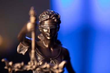 Avukatlık bürosu. Kanun sembolleri: Heykel ve ölçek. Mavi ışık arkaplanı.