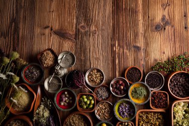  Doğal tıp geçmişi. Kâselerde çeşitli kuru otlar ve rustik ahşap masa üzerinde pirinç havan..