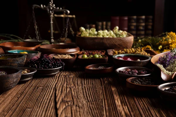  Doğal tıp geçmişi. Kâselerde çeşitli kuru otlar ve rustik ahşap masa üzerinde pirinç havan..