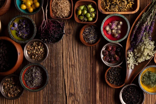  Doğal tıp geçmişi. Kâselerde çeşitli kuru otlar ve rustik ahşap masa üzerinde pirinç havan..