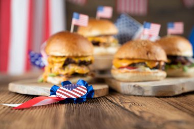 4 Temmuz kutlamaları. Amerikan bayrağı ve madalyaları. Köy ahşap masada hamburgerler.