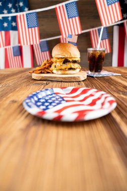 4 Temmuz kutlamaları. Amerikan bayrağı ve madalyaları. Köy ahşap masada hamburgerler.