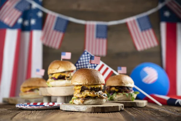 4 Temmuz kutlamaları. Amerikan bayrağı ve madalyaları. Köy ahşap masada hamburgerler.