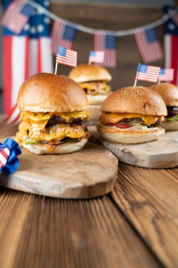 4 Temmuz kutlamaları. Amerikan bayrağı ve madalyaları. Köy ahşap masada hamburgerler.
