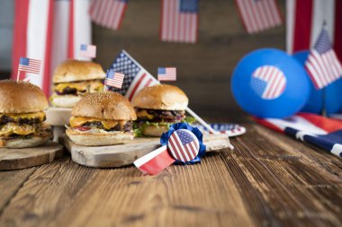 4 Temmuz kutlamaları. Amerikan bayrağı ve madalyaları. Köy ahşap masada hamburgerler.