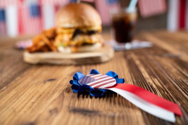 4 Temmuz kutlamaları. Amerikan bayrağı ve madalyaları. Köy ahşap masada hamburgerler.
