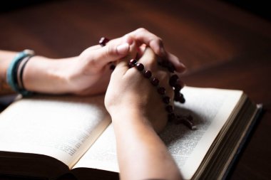 Hıristiyanlık temalı dua. İncil 'i olan Hristiyan bir kadın ellerini çapraz tutarak dua ediyor..