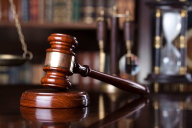 Yargıç ofisi. Gavel ve tartıyı yargıç masasına koy. Arkaplanda kitap rafı.