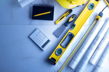 Müteahhit teması. Müteahhitin planları, defter ve alet çantası: sarı başlık, karalama ve ölçü.. 