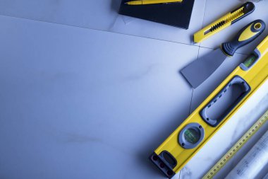 Müteahhit teması. Müteahhitin planları, defter ve alet çantası: sarı başlık, karalama ve ölçü.. 