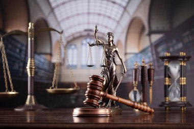 Law theme. Themis statue, scale and judge gavel in the law faculty library.