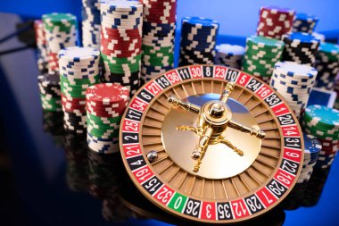 Casino. Gambling games theme.  Roulette wheel, dice and poker chips on the blue background.