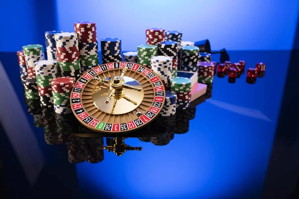 Casino. Gambling games theme.  Roulette wheel, dice and poker chips on the blue background.
