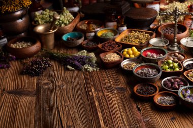 Doğal tıp geçmişi. Kırsal ahşap masadaki çeşitli kuru otlar, havan ve bitkiler..