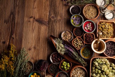 Doğal tıp geçmişi. Kırsal ahşap masadaki çeşitli kuru otlar, havan ve bitkiler..