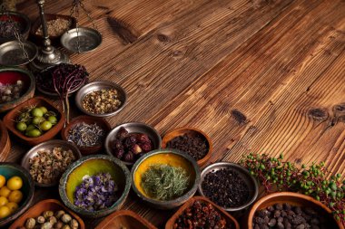 Doğal tıp geçmişi. Kırsal ahşap masadaki çeşitli kuru otlar, havan ve bitkiler..