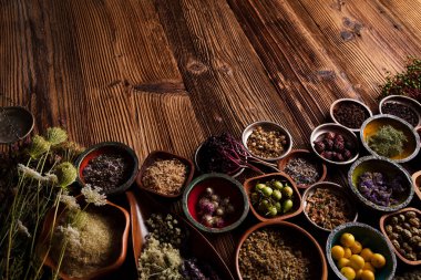 Doğal tıp geçmişi. Kırsal ahşap masadaki çeşitli kuru otlar, havan ve bitkiler..