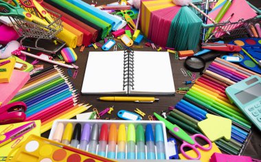 School supplies. Set of colorful school accessories isolated on the brown wooden background. Top view.