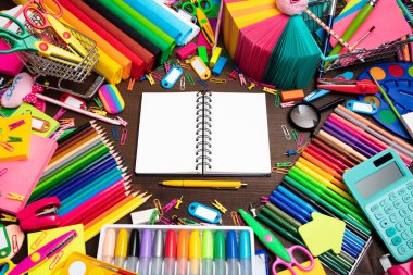 School supplies. Set of colorful school accessories isolated on the brown wooden background. Top view.