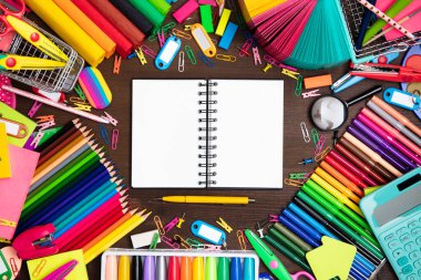 School supplies. Set of colorful school accessories isolated on the brown wooden background. Top view.