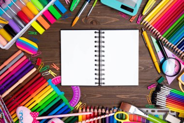 School supplies. Set of colorful school accessories isolated on the brown wooden background. Top view.