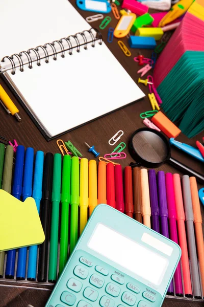 School supplies. Set of colorful school accessories isolated on the brown wooden background. Top view.