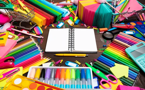 School supplies. Set of colorful school accessories isolated on the brown wooden background. Top view.
