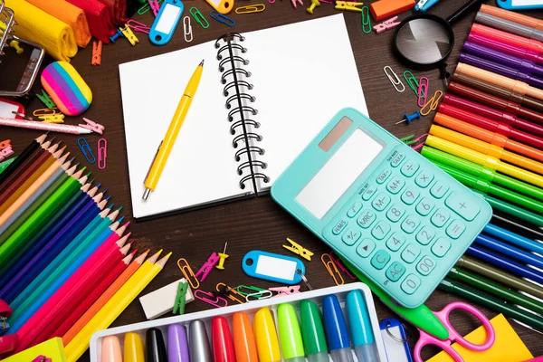 School supplies. Set of colorful school accessories isolated on the brown wooden background. Top view.