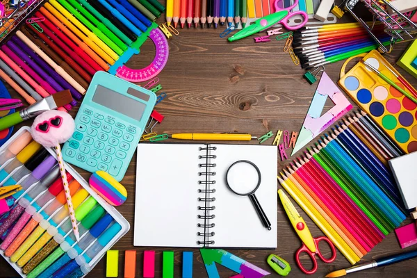 School supplies. Set of colorful school accessories isolated on the brown wooden background. Top view.