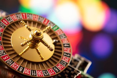 Casino. Roulette wheel, dice and poker chips on the colorful bokeh background.